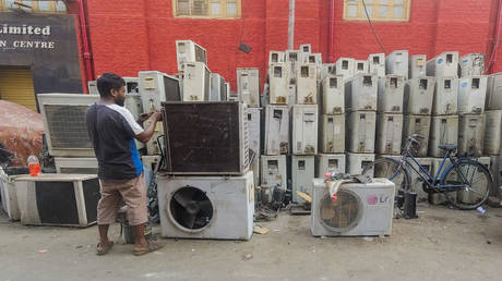 Stacks of used air conditioners are up for sale and recycling at a marketplace in Kolkata, India, on March 19, 2025.
