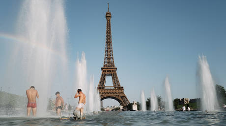 Parisians and tourists cool off at the Trocadero fountain in Paris, France, on July 1, 2025.