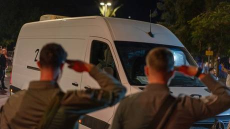 Israeli officers pay their respects as the remains of hostages are returned from Gaza to Tel Aviv on October 13, 2025.