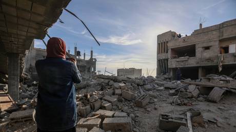 FILE PHOTO. People inspect the damage to their homes following Israeli air strikes in Rafah, Gaza.