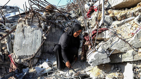 A Palestinian mother pictured in the wreckage of her home, destroyed in an Israeli attack in Khan Yunis, Gaza on November 1, 2025.