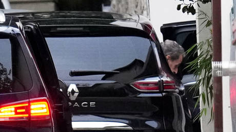 Former French President Nicolas Sarkozy leaves his car as he arrives at his home after being released from prison, November 10, 2025 in Paris.