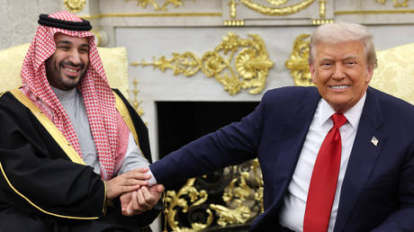 US President Donald Trump (R) takes the hand of Crown Prince and Prime Minister Mohammed bin Salman of Saudi Arabia during a bilateral meeting in the Oval Office of the White House on November 18, 2025 in Washington, DC.
