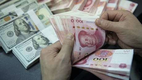 A bank employee is counting the Chinese Yuan.