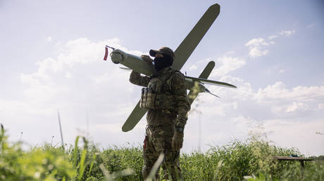 A Ukrainian service members poses for a photo with a Bulava strike drone on May 22, 2026, in Kharkov Region, Ukraine.